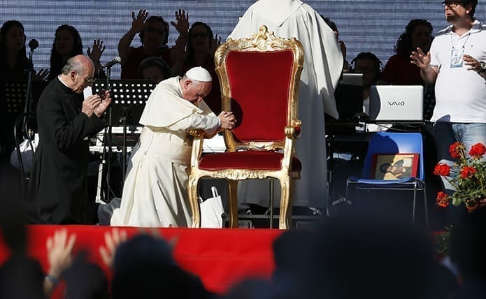 Pope Francis kneels as the crowd prays over him by singing and speaking in tongues during an encounter with more than 50,000 Catholic charismatics at the Olympic Stadium in Rome June 1.